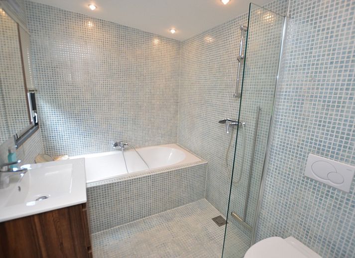 Helles Wohnzimmer des Ferienhauses 't Hoogelandt 202 - Aan Zee, Texel mit Blick auf den Garten in De Dennen.