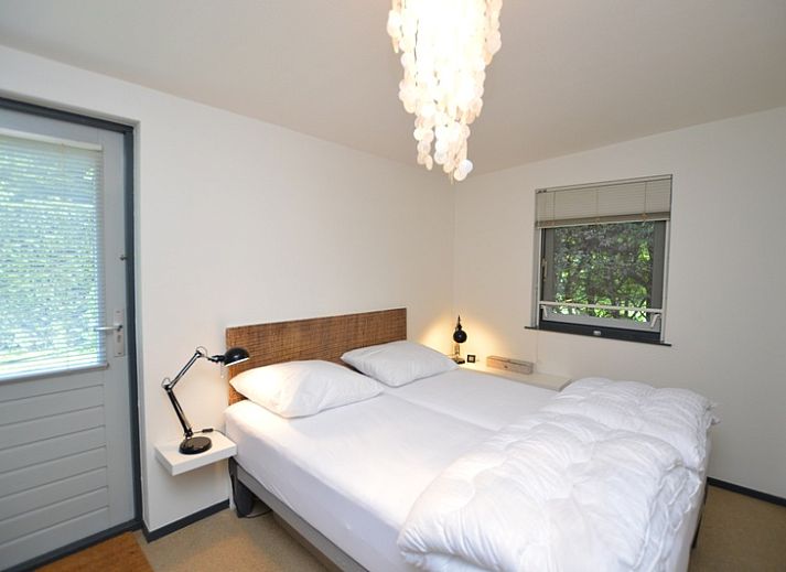 Helles Wohnzimmer des Ferienhauses 't Hoogelandt 202 - Aan Zee, Texel mit Blick auf den Garten in De Dennen.