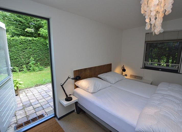 Helles Wohnzimmer des Ferienhauses 't Hoogelandt 202 - Aan Zee, Texel mit Blick auf den Garten in De Dennen.