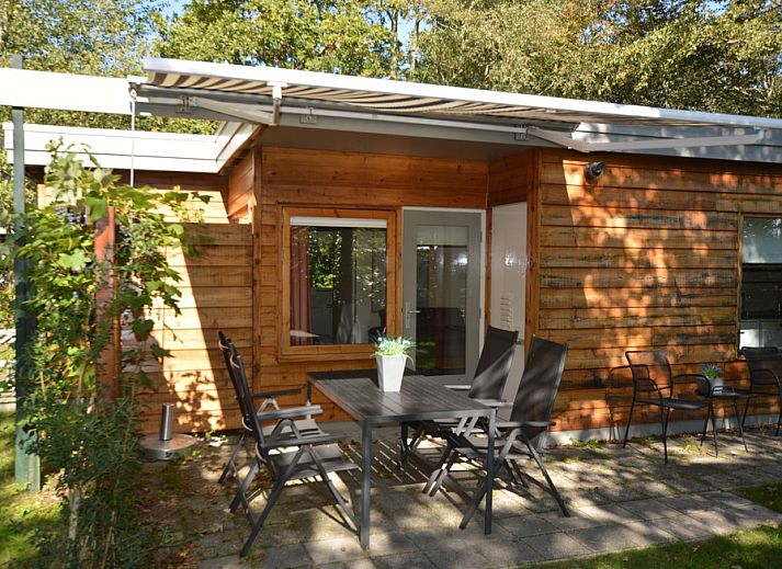 Veranda van Vakantiehuis De Nagtegaal 19 in De Dennen Texel met houten gevel en tuinmeubilair.