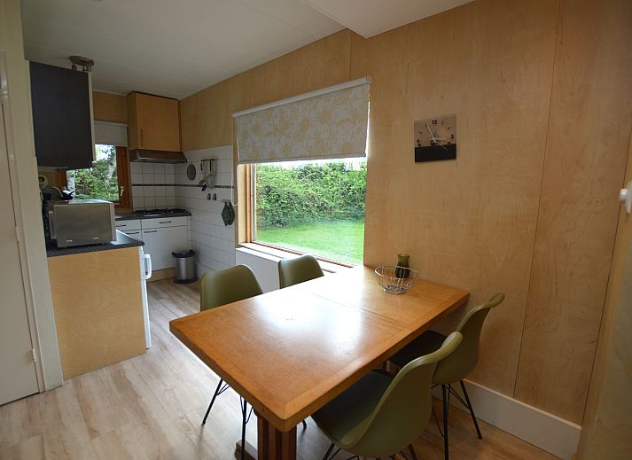 Lichte woonruimte van Vakantiehuis De Nagtegaal 19 in De Dennen Texel met uitzicht op groene tuin.