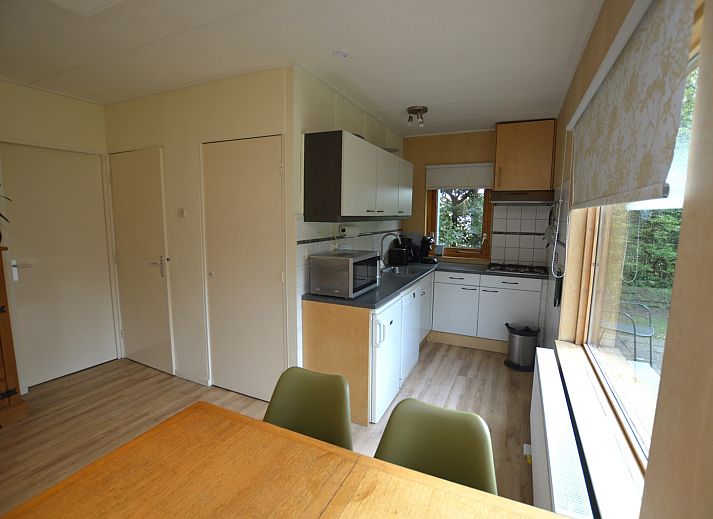 Lichte woonruimte van Vakantiehuis De Nagtegaal 19 in De Dennen Texel met uitzicht op groene tuin.