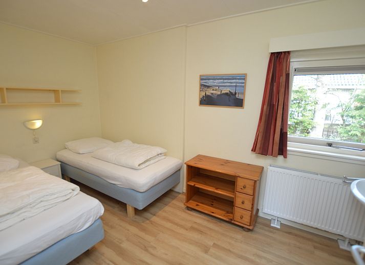 Lichte woonruimte van Vakantiehuis De Nagtegaal 19 in De Dennen Texel met uitzicht op groene tuin.