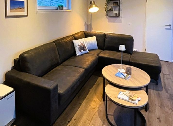 Gemuetliches Wohnzimmer im Ferienpark De Bremakker - Bosveld 137, De Dennen, Texel. Modernes Ferienhaus mit geraeumiger Sitzecke und Kueche.