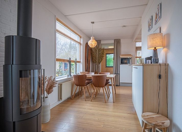 Gezellig terras bij Bungalowpark 't Luwe Land - 7B - De Wijnhof, De Dennen, Texel, omgeven door groene heggen.