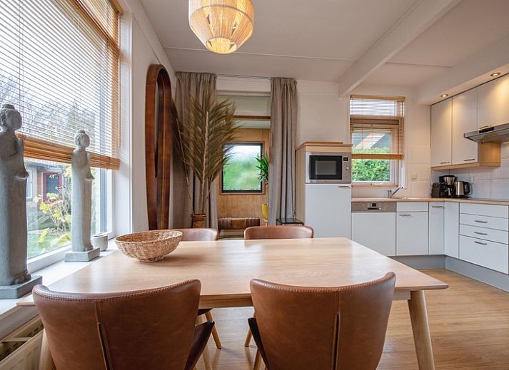 Gezellig terras bij Bungalowpark 't Luwe Land - 7B - De Wijnhof, De Dennen, Texel, omgeven door groene heggen.