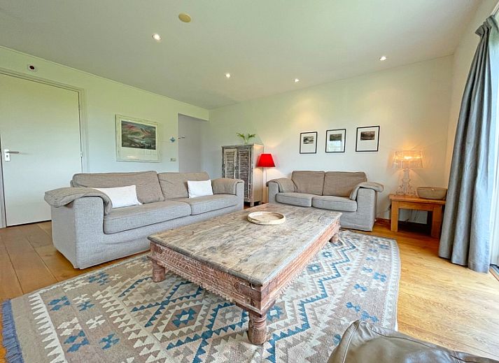 Gemuetliches Wohnzimmer im Appartement Bos en Duin 40, De Dennen, Texel mit bequemer Sitzecke und Blick auf die Natur.