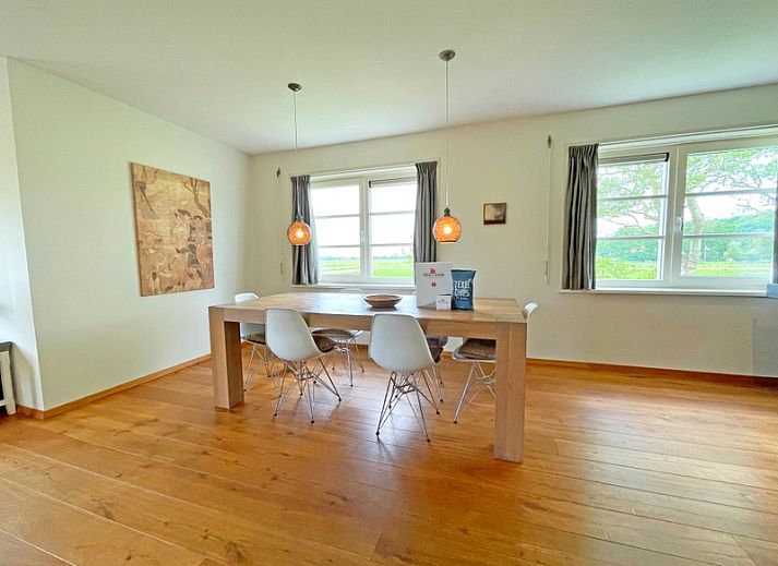 Gemuetliches Wohnzimmer im Appartement Bos en Duin 40, De Dennen, Texel mit bequemer Sitzecke und Blick auf die Natur.