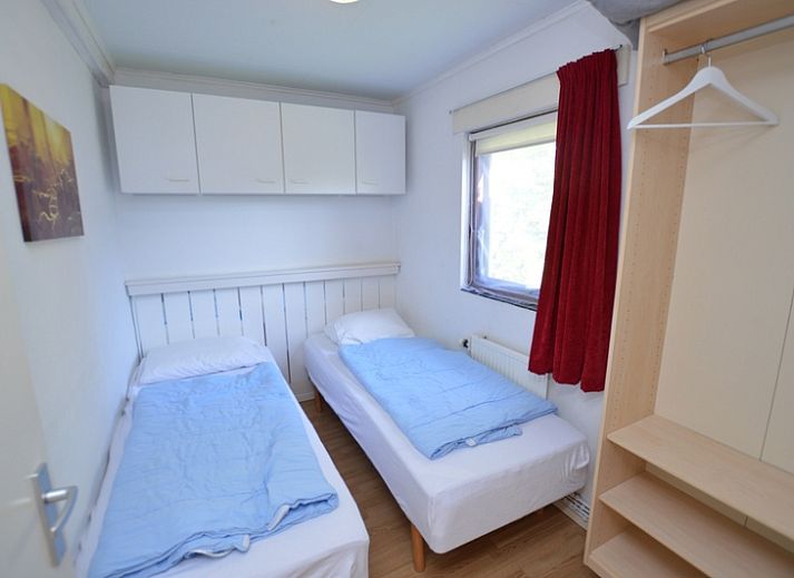 Lichte woonkamer van Vakantiehuis de Parel 222, Texel met uitzicht op de tuin.