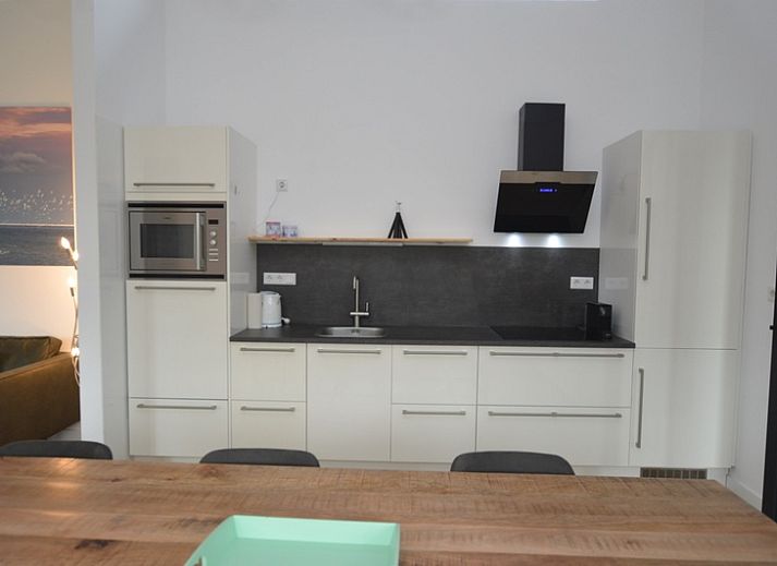 Gezellige woonkamer in Bungalow Uterste Coogh 132, De Dennen, Texel met comfortabele zitplaatsen.