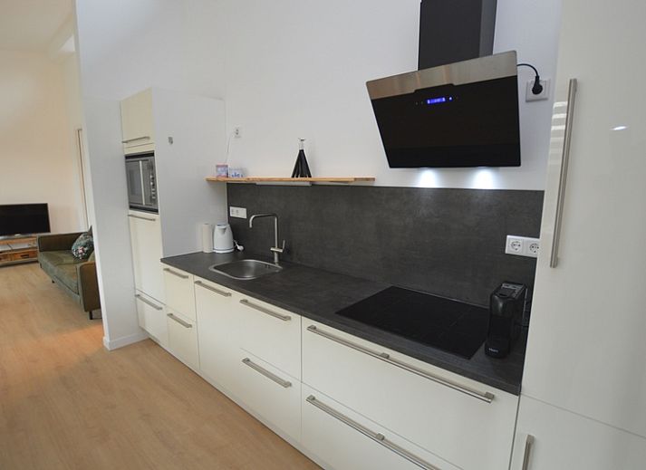 Gezellige woonkamer in Bungalow Uterste Coogh 132, De Dennen, Texel met comfortabele zitplaatsen.