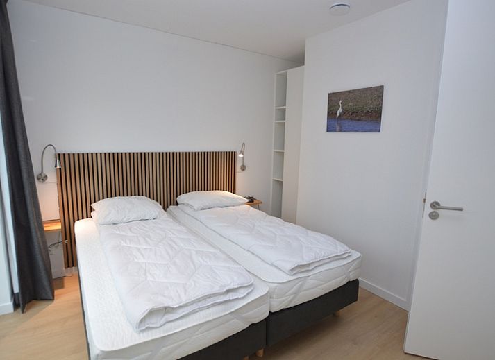 Ruime woonkamer met uitzicht op de tuin in Bungalow Uterste Coogh 132, De Dennen, Texel.