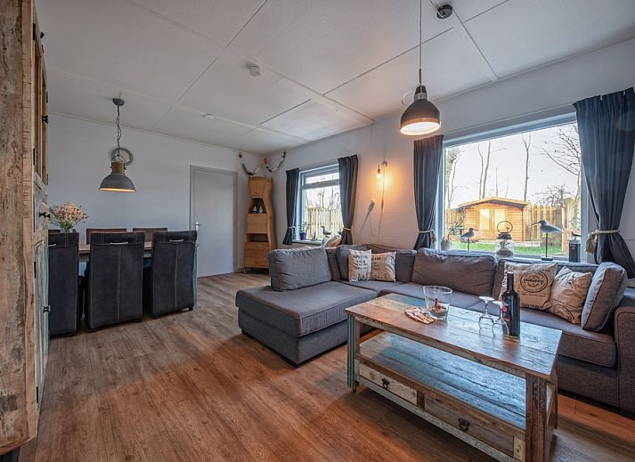 Gemuetliches Wohnzimmer im Ferienhaus Flora, De Dennen, Texel. Gemuetliche Sitzecke mit Blick auf den Garten dieses Ferienhauses auf den Watteninseln.