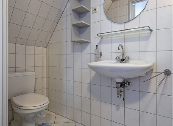 Gemuetliches Wohnzimmer des Ferienhauses Flora in De Dennen, Texel, mit geraeumiger Sitzecke und Gartenblick, ideal zum Entspannen.