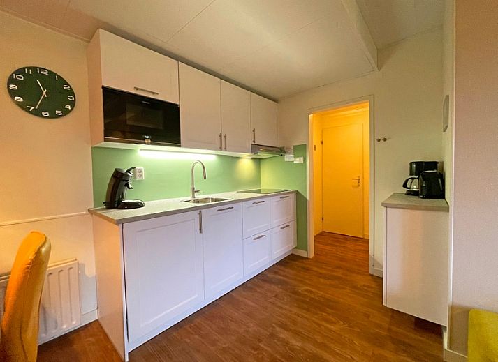 Ruime zithoek in Appartement Bos en Duin 15, De Dennen, Texel met moderne inrichting en toegang tot het terras.