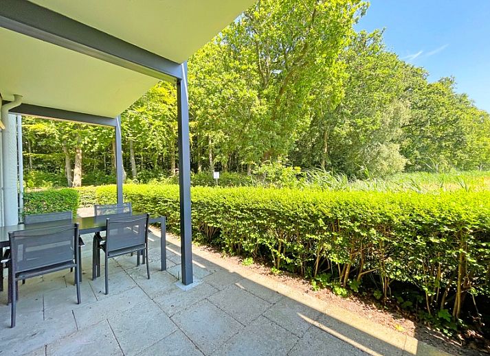 Ruime zithoek in Appartement Bos en Duin 15, De Dennen, Texel met moderne inrichting en toegang tot het terras.