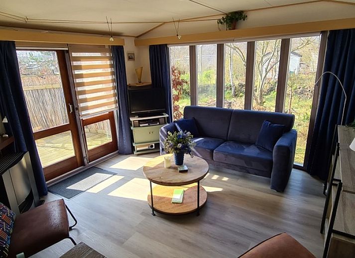 Innenraum des Ferienhauses im Vakantiepark De Bremakker, Texel, mit einem gemuetlichen Wohnzimmer und viel Licht.