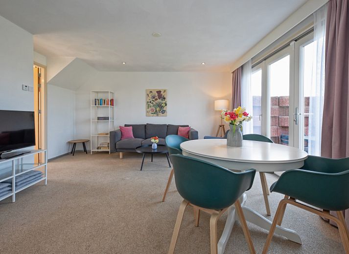 Aussenansicht von Haus 6, einem charmanten Ferienhaus in De Dennen, Texel, mit sonniger Terrasse und gruener Umgebung.