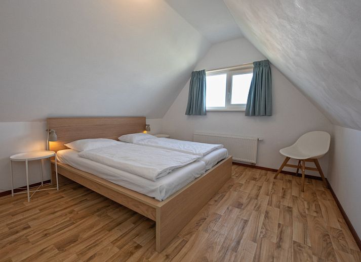 Gemuetliches Wohnzimmer von Cottage 6 in De Dennen, Texel, mit bequemer Sitzecke und Gartenblick.