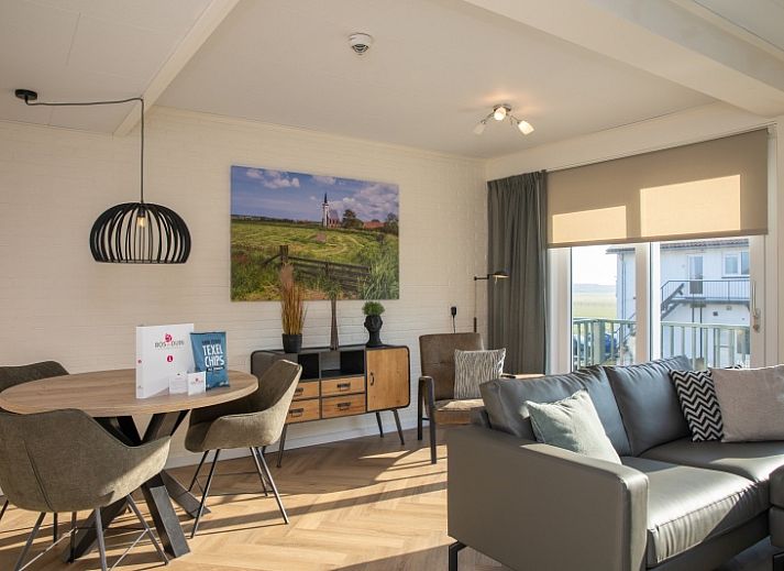 Gezellige woonkamer in Appartement Bos en Duin 28, De Dennen, Texel met comfortabele zithoek en uitzicht op de natuur.