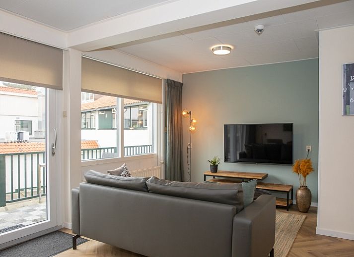 Gezellige woonkamer in Appartement Bos en Duin 28, De Dennen, Texel met comfortabele zithoek en uitzicht op de natuur.