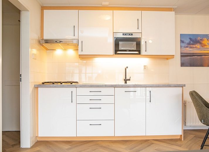 Lichte en moderne leefruimte in Appartement Bos en Duin 28, De Dennen, Texel met eet- en zitgedeelte.