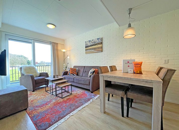 Gemuetliches Wohnzimmer im Apartment Bos en Duin 31, De Dennen, Texel mit bequemem Sofa und Blick auf die Natur.