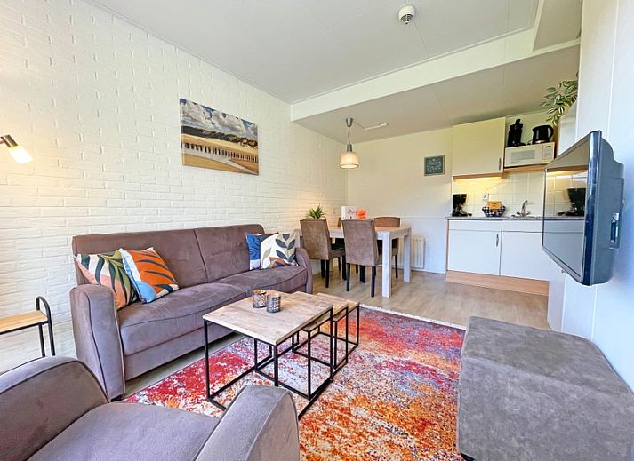 Gemuetliches Wohnzimmer im Apartment Bos en Duin 31, De Dennen, Texel mit bequemem Sofa und Blick auf die Natur.