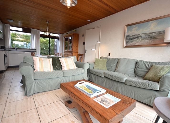 Aussenterrasse des Ferienhauses de Parel 258 in De Dennen, Texel, mit Gartenmoebeln und gruener Umgebung.