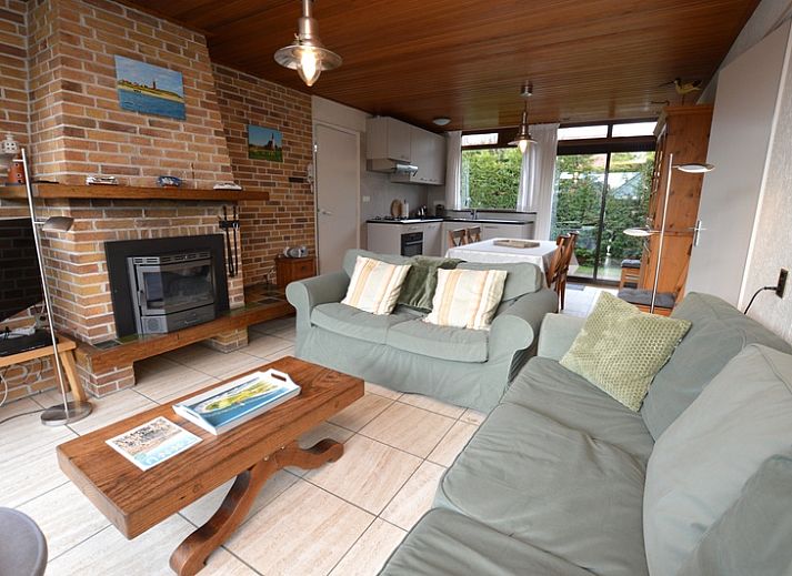 Aussenterrasse des Ferienhauses de Parel 258 in De Dennen, Texel, mit Gartenmoebeln und gruener Umgebung.