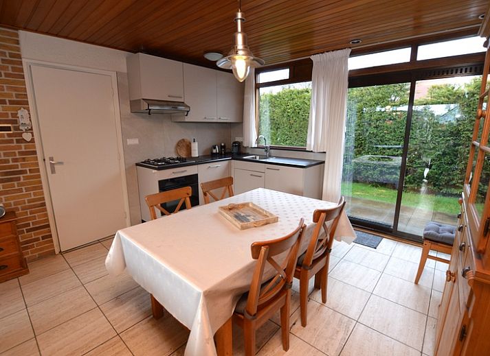 Gemuetliches Wohnzimmer im Holiday home de Parel 258, De Dennen, Texel, mit bequemen Sofas und Blick auf den Garten.