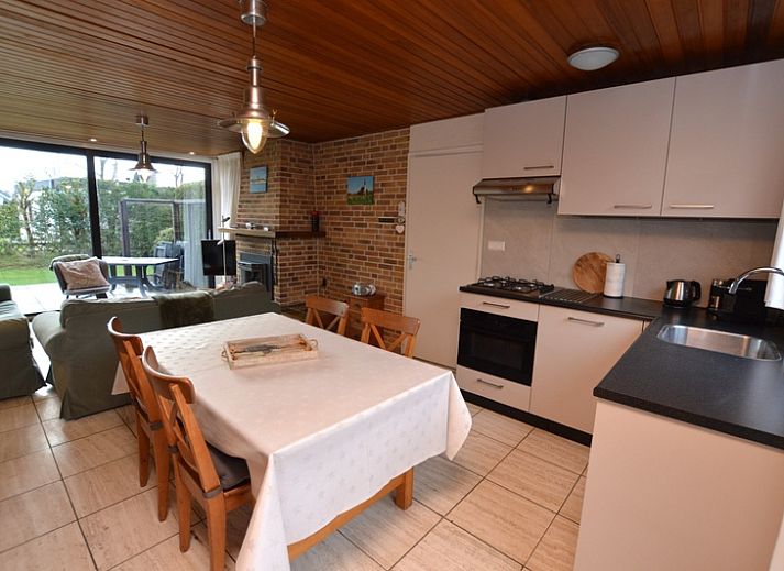 Gemuetliches Wohnzimmer im Holiday home de Parel 258, De Dennen, Texel, mit bequemen Sofas und Blick auf den Garten.