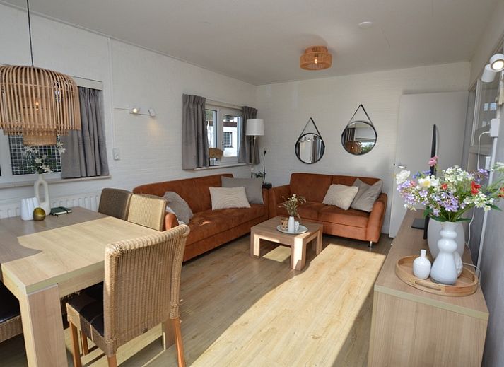 Lichte woonkamer van Bungalow Uterste Coogh 96 in De Dennen, Texel, met comfortabele banken en eethoek op de Waddeneilanden.