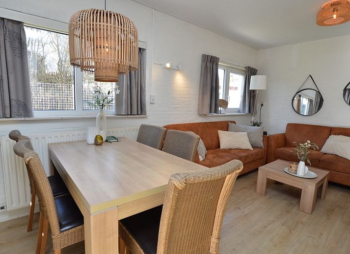 Lichte woonkamer van Bungalow Uterste Coogh 96 in De Dennen, Texel, met comfortabele banken en eethoek op de Waddeneilanden.