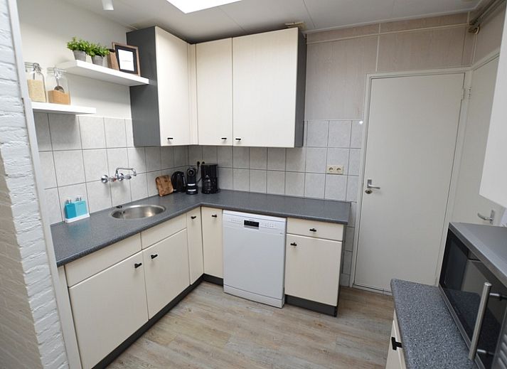 Lichte woonkamer van Bungalow Uterste Coogh 96 in De Dennen, Texel, met comfortabele banken en eethoek op de Waddeneilanden.