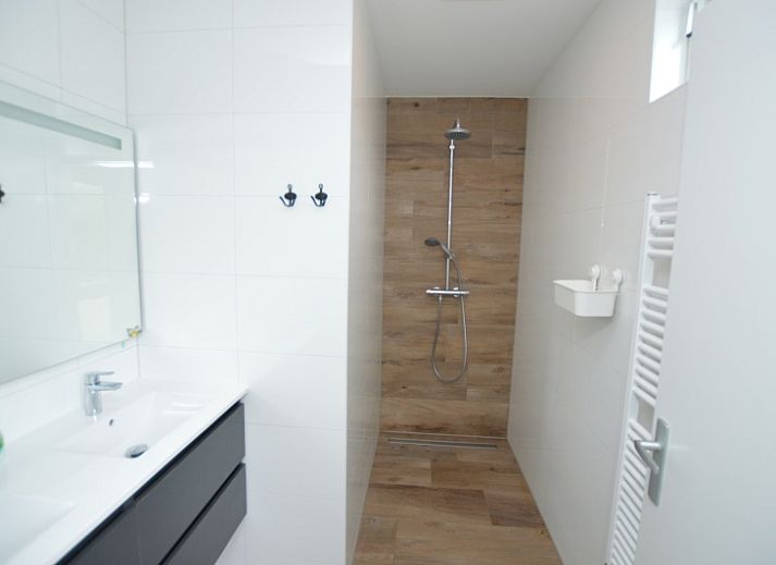 Helles Wohnzimmer im Ferienhaus Tempelierweg 16 - de Brunaire, De Dennen, Texel mit Blick auf den gruenen Garten, ideal fuer Familienurlaub.