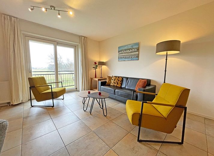 Gezellige woonkamer in Appartement Bos en Duin 41 in De Dennen, Texel met comfortabele zitplaatsen en veel natuurlijk licht.