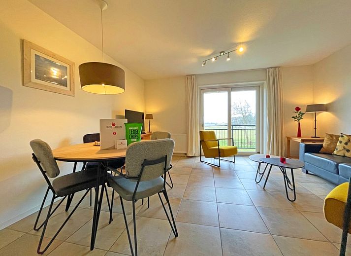 Gezellige woonkamer in Appartement Bos en Duin 41 in De Dennen, Texel met comfortabele zitplaatsen en veel natuurlijk licht.