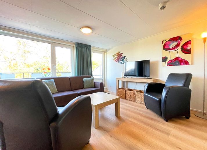Geraeumiges Wohnzimmer im Appartement Bos en Duin 21, De Dennen, Texel mit moderner Einrichtung und gemuetlicher Sitzecke.