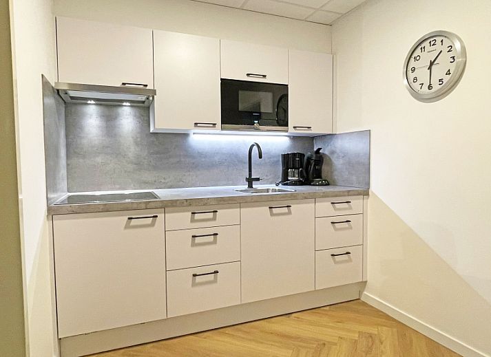 Gemuetliches Wohnzimmer des Appartements Bos en Duin 04 in De Dennen, Texel, mit bequemen Moebeln und viel natuerlichem Licht.