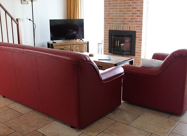 Gezellige woonkamer met open keuken in Vakantiehuis Gortersmient 282, De Dennen, Texel voor een comfortabel verblijf.