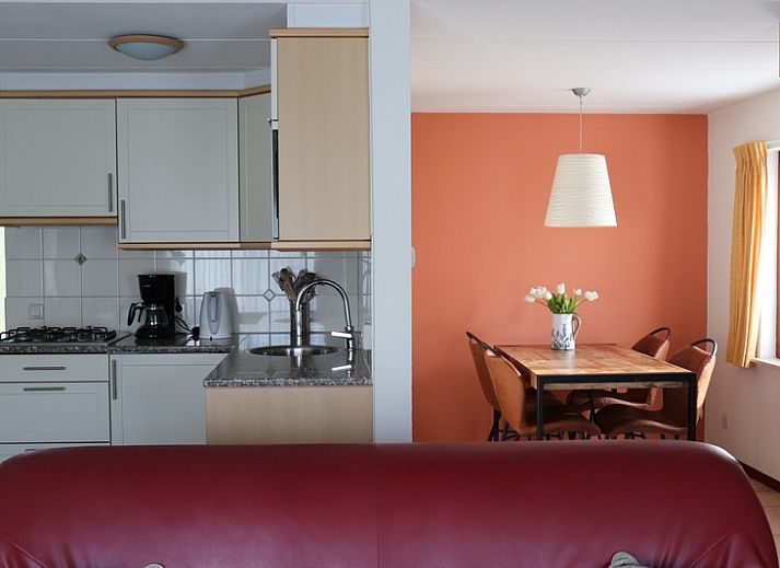 Gezellige woonkamer met open keuken in Vakantiehuis Gortersmient 282, De Dennen, Texel voor een comfortabel verblijf.