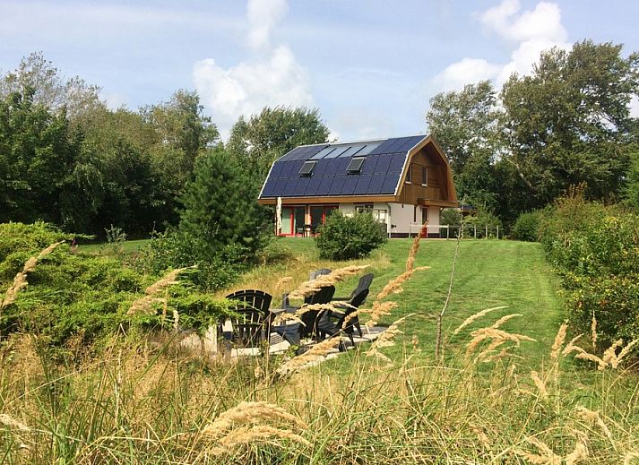 Vijverhof Ferienhaus fuer 6 Personen in De Dennen, Texel, umgeben von ueppiger Natur und einem sonnigen Garten, ideal fuer einen entspannten Aufenthalt.