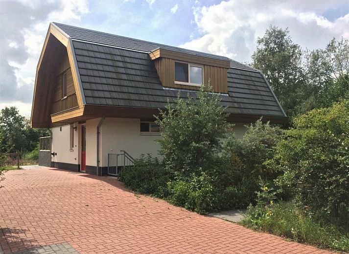 Vijverhof Ferienhaus fuer 6 Personen in De Dennen, Texel, umgeben von ueppiger Natur und einem sonnigen Garten, ideal fuer einen entspannten Aufenthalt.