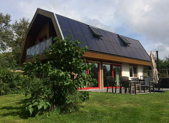 Vijverhof Ferienhaus fuer 6 Personen in De Dennen, Texel, umgeben von ueppiger Natur und einem sonnigen Garten, ideal fuer einen entspannten Aufenthalt.
