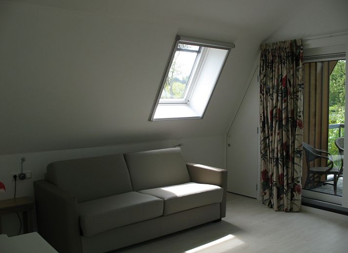 Vijverhof Ferienhaus fuer 6 Personen in De Dennen, Texel, umgeben von ueppiger Natur und mit einer einladenden Terrasse.