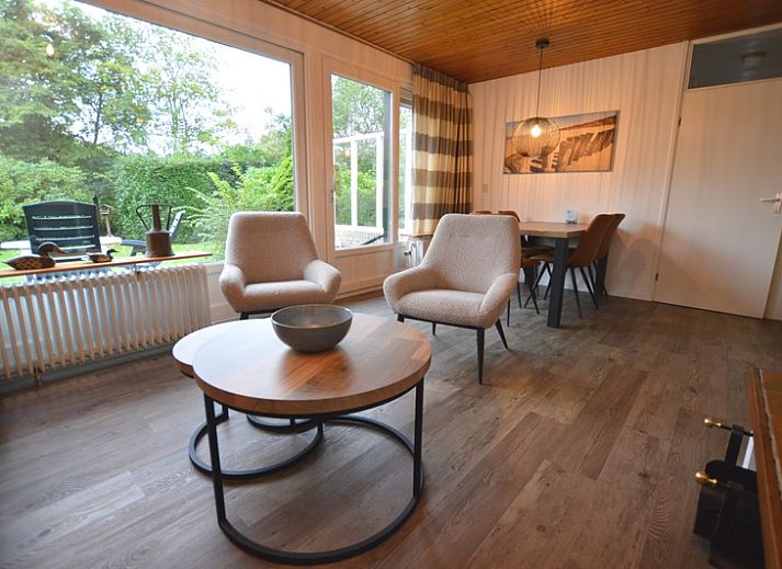 Gemuetliches Wohnzimmer des Ferienhauses de Parel 234 in De Dennen, Texel mit Blick auf den Garten.