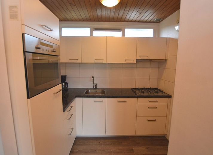 Gemuetliches Wohnzimmer des Ferienhauses de Parel 234 in De Dennen, Texel mit Blick auf den Garten.