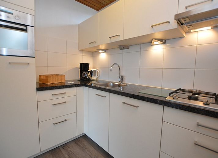 Gemuetliches Wohnzimmer des Ferienhauses de Parel 234 in De Dennen, Texel mit Blick auf den Garten.