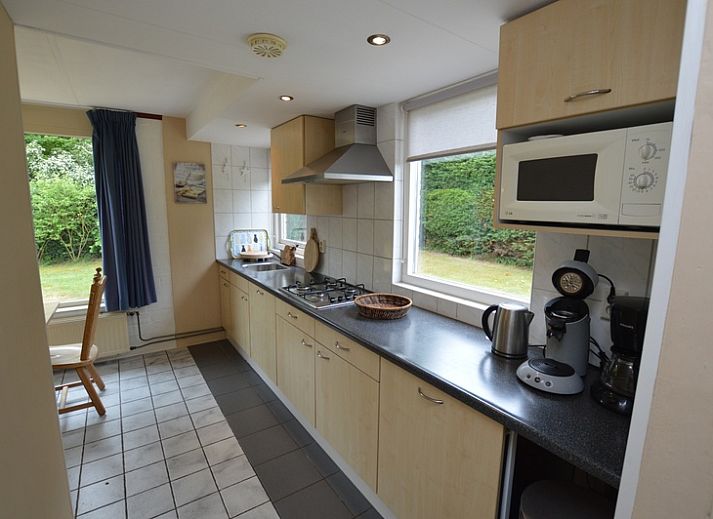 Gezellige woonkamer in Bungalow Verste Coogh 56, De Dennen, Texel, met comfortabele banken en uitzicht op de natuur.